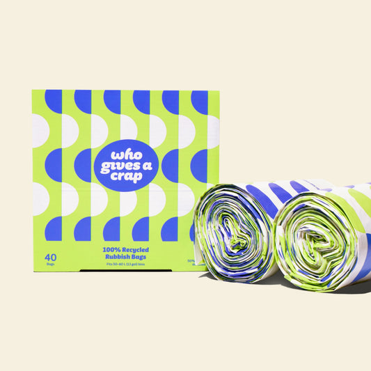Two rolls and a box of Who Gives a Crap large recycled trash bags with green and blue packaging