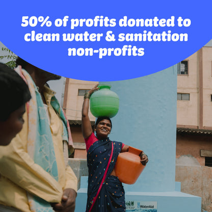 Walking woman carries containers of water on head and hip and smiles. Image by WaterAid (Abhijit). Who Gives A Crap donates 50% of profits to clean water & sanitation non-profits.
