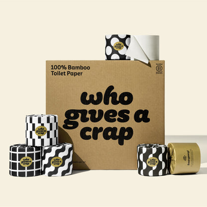 A large box of Who Gives A Crap 100% Bamboo Toilet Paper with black and white wrappers - eco-friendly, biodegradable and sustainable toilet paper